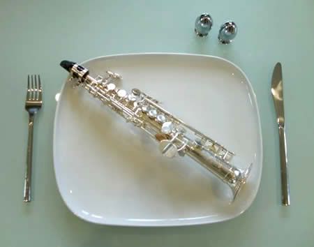 dinner place setting with soprano saxophone on plate